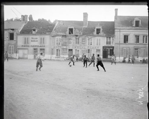 Soldats français jouant au football sur une place